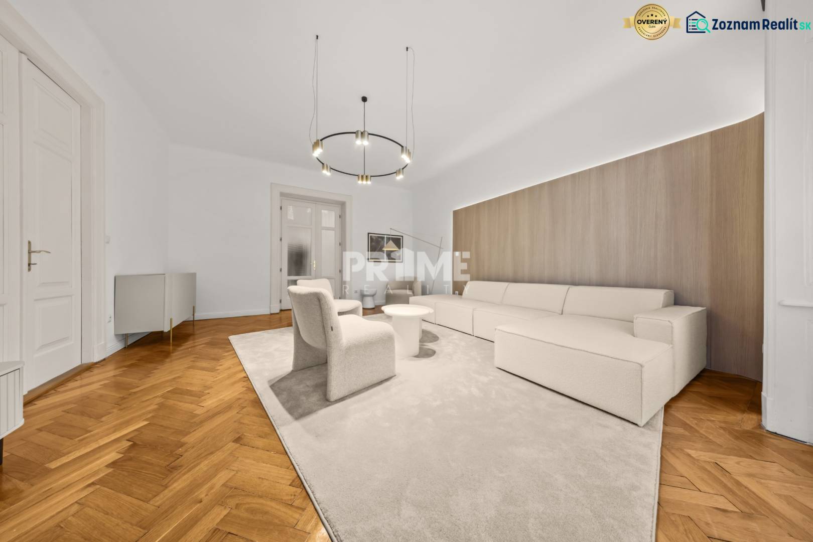  EXKLUZÍVNY, VEĽKOMETRÁŽNY 3i byt ( 130 m2 ), REKONŠTRUKCIA, CENTRUM - Obývacia izba v 3-izbovom byte s béžovou sedačkou a podlahou s dreveným dekorom.