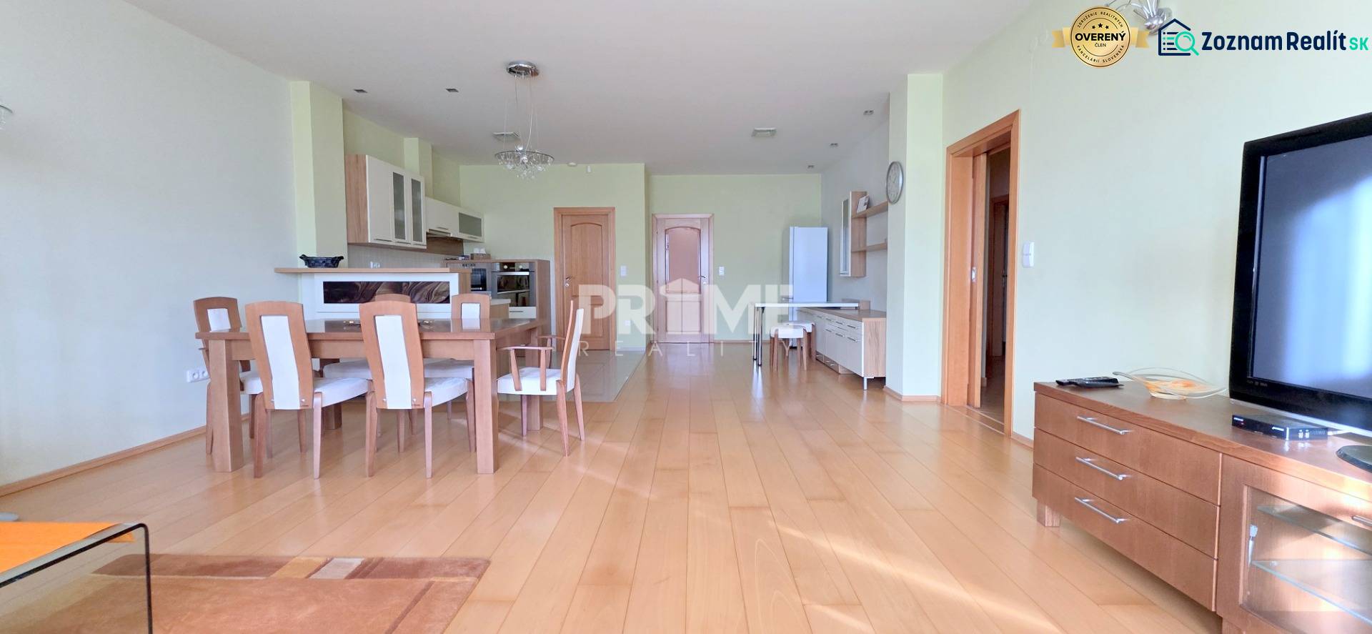 VEĽKOMETRÁŽNY 3i byt, 3 x NEPRIECHODNÁ IZBA, KLÍMA, BALKÓN, Nám.SNP - 3-izbový byt s podlahou s dreveným dekorom, jedálenským stolom a otvorenou kuchyňou.