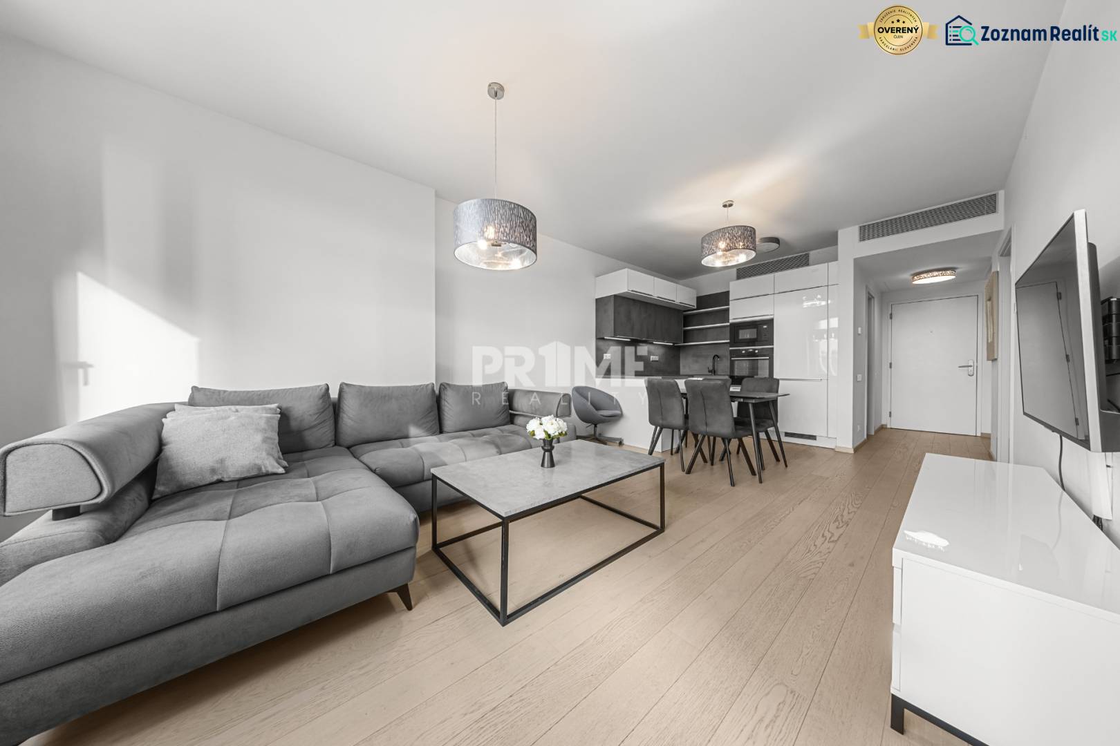 ŠTÝLOVÝ 2i byt,SKY PARK,VÝHĽAD,LOGGIA,PARKING,VEŽA II,Továrenská ul. - Obývacia izba v 2-izbovom byte s pohovkou a podlahou s dreveným dekorom.