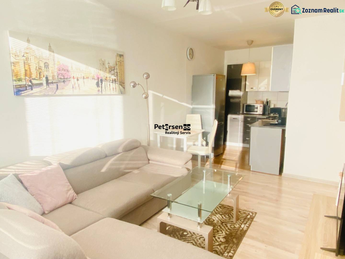 NA PRENÁJOM PEKNÝ 2-IZBOVÝ BYT, TERASA - Obývačka s pohovkou a kuchyňou, 2-izbový byt, podlaha s dreveným dekorom.