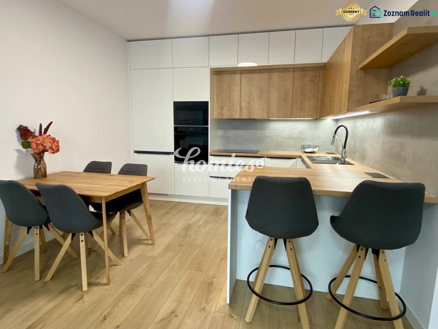PRENÁJOM luxusný 2 izbový byt v centre mesta Nitra, parkovanie - Kuchyňa v 2-izbovom byte s podlahou s dreveným dekorom, jedálenským stolom a barovým pultom.
