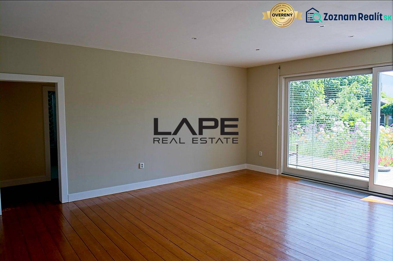 Rodinný dom s veľkou záhradou - Ružinov  - Interiér v rodinnom dome s podlahou s dreveným dekorom a veľkými oknami.