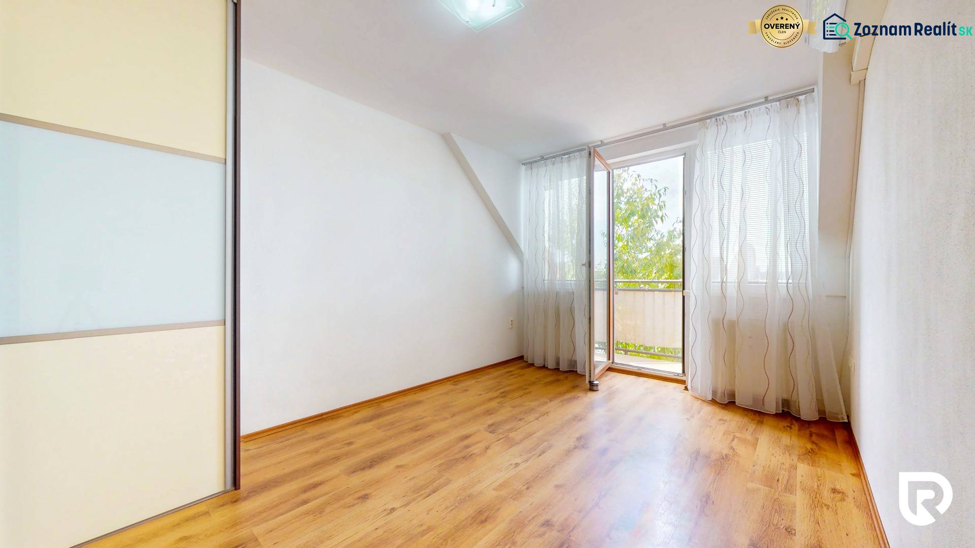 2iz byt v novostavbe s parkovaním | Podunajské Biskupice | 57m2 - Izba s balkónovými dverami a podlahou s dreveným dekorom v 2-izbovom byte.