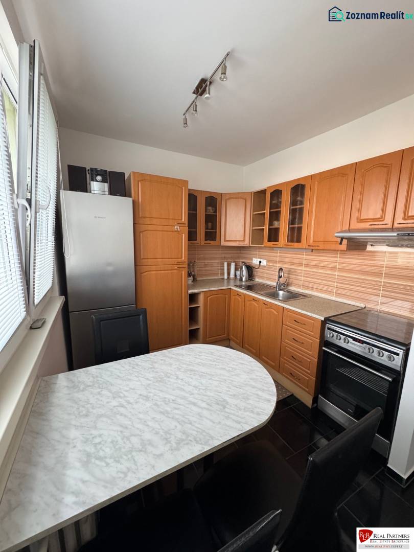 Prenájom 2-izb bytu v Bratislave-Rača - Kuchyňa v 2-izbovom byte s drevenými skrinkami a mramorovým stolom.