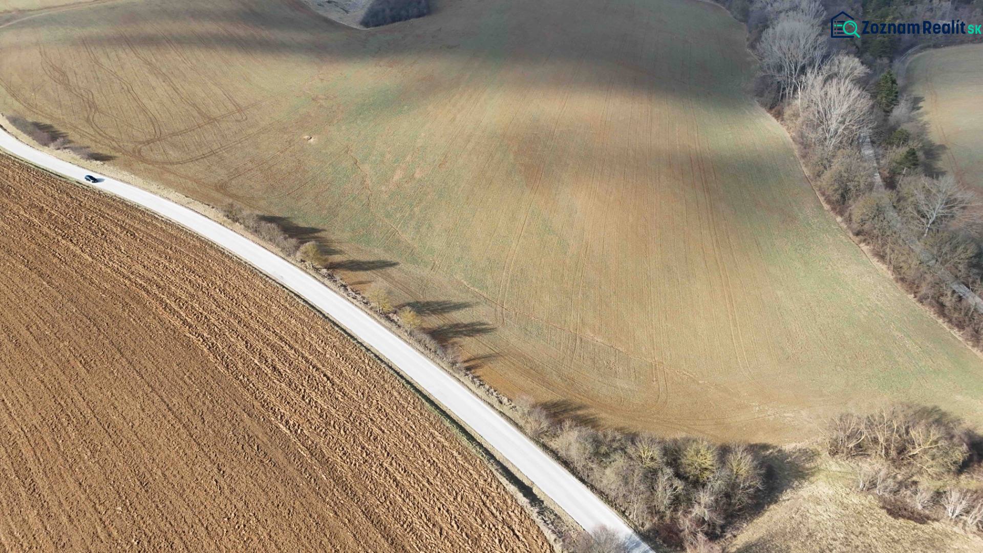 Lubina – Poľnohospodárska pôda v podiele 1/1 - Letecký pohľad na poľnohospodárske pozemky s lesnými okrajmi a cestou v kraji.