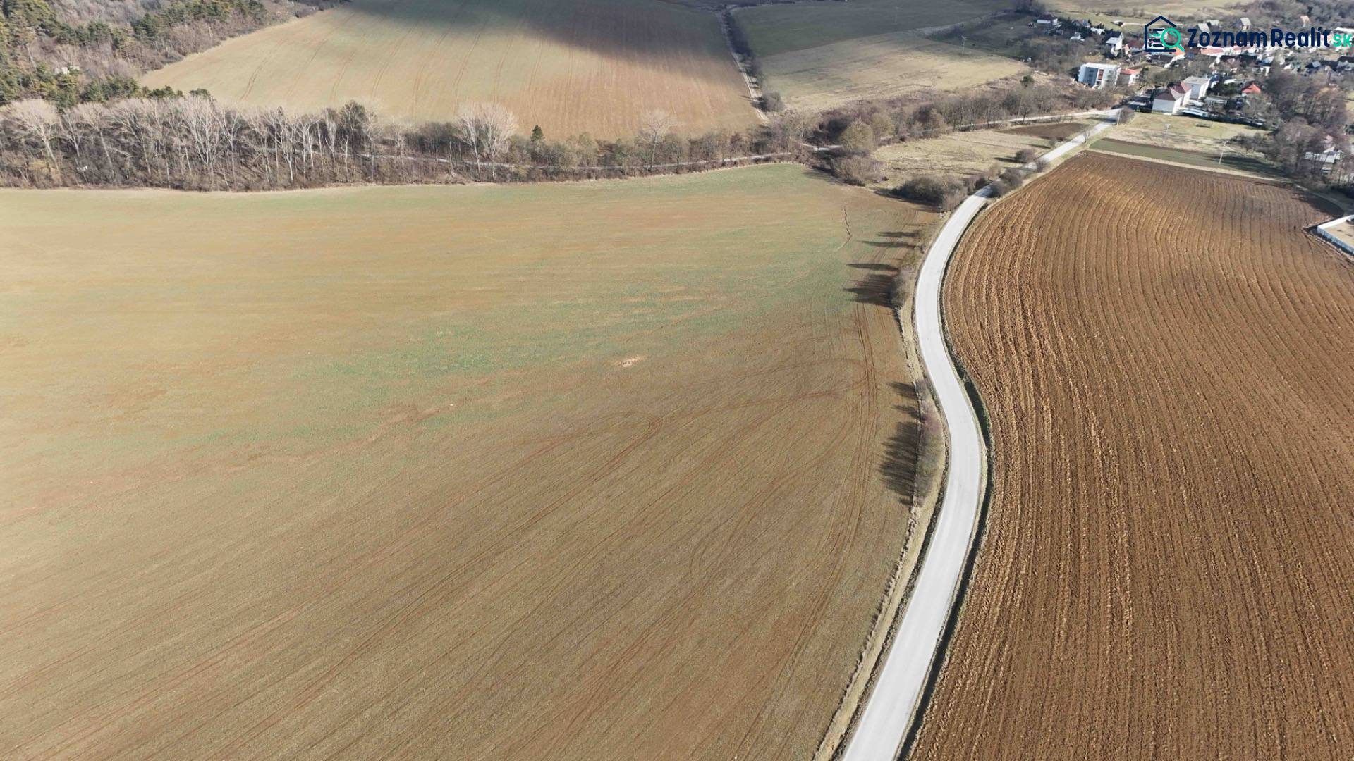 Lubina – Poľnohospodárska pôda v podiele 1/1 - Letecký pohľad na poľnohospodárske pozemky s prístupovou cestou a lesnými okrajmi.