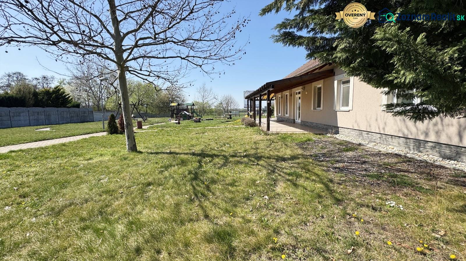 Ponúkame na predaj  komerčnú budovu v Marianke ! - Záhrada pri dome s trávnikom, stromami a detským ihriskom, ideálna na obchodné priestory.