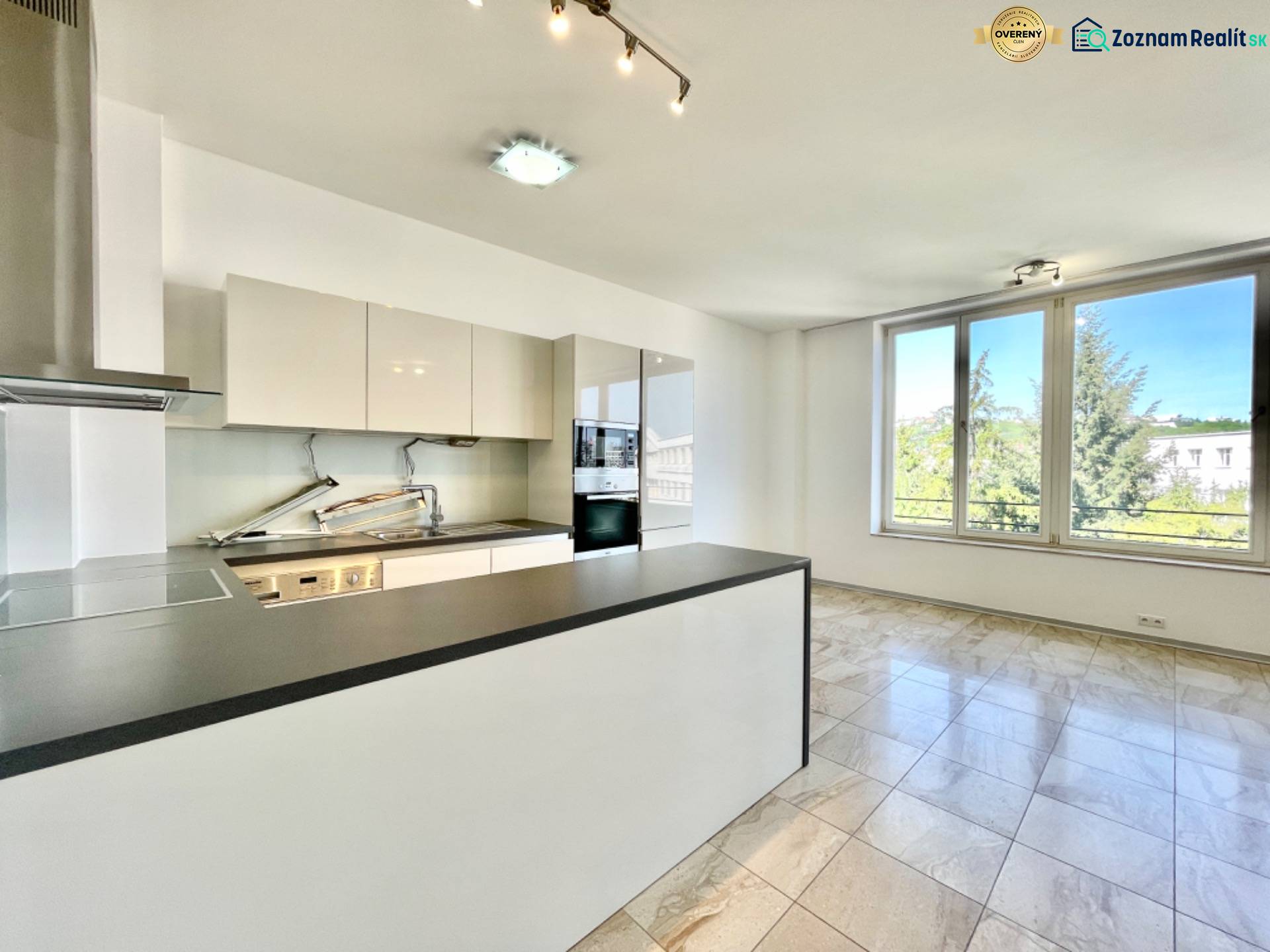 | A4.7 Rezidenčný nadštandardný byt na ul. Hlboká cesta - Kuchyňa v 3-izbovom byte s veľkými oknami a dlažbou.