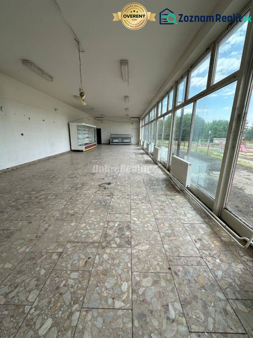 Dobré reality - Polyfunkčný objekt na predaj - Interiér budovy so sklenenými stenami a kamennou podlahou, prázdna miestnosť.