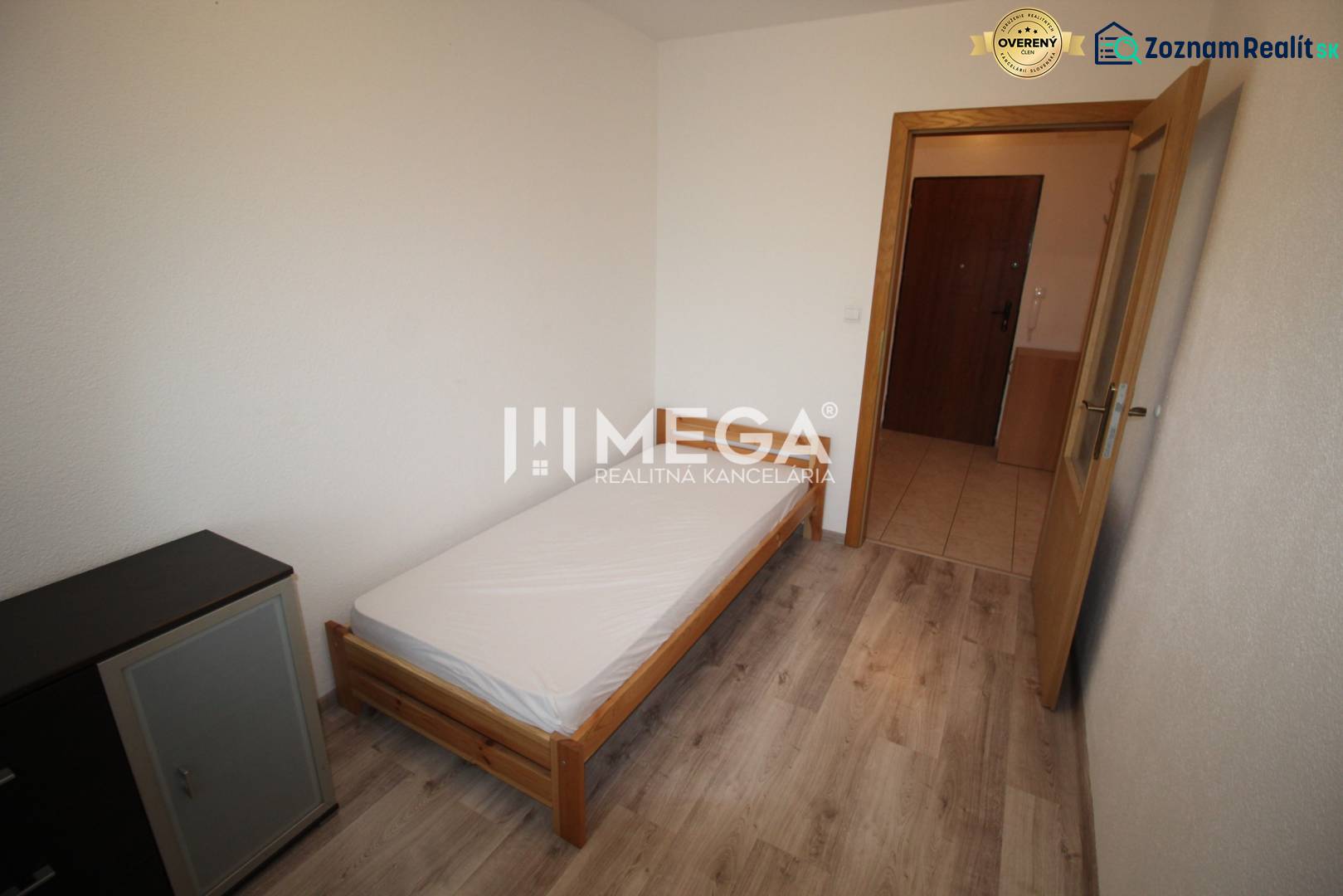 NA PRENÁJOM 1,5-IZB. BYT V MESTE HUMENNÉ - Spálňa s posteľou, komodou a podlahou s dreveným dekorom v 2-izbovom byte.