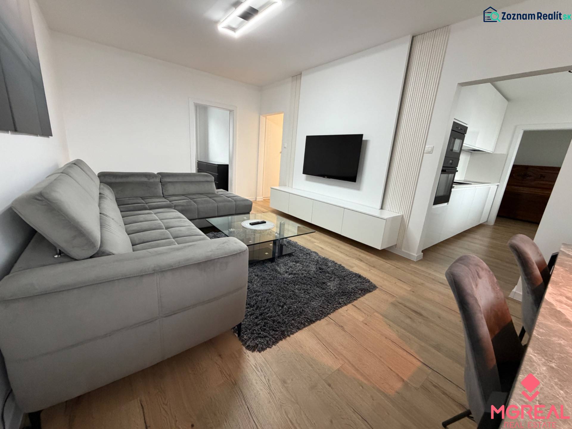 3 izbový byt s balkónom Topoľčany / PRENAJOM  - Obývačka so sivou sedačkou, televízorom a podlahou s dreveným dekorom v 3-izbovom byte.