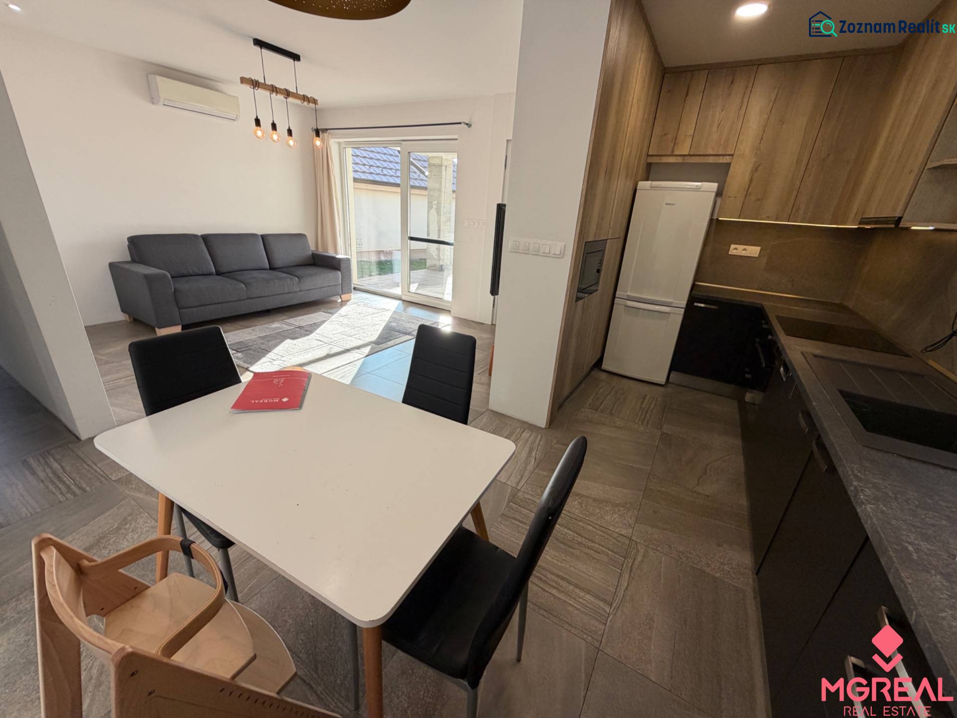 Novostavba rodinný dom Ludanice / REZERVOVANE - Interiér rodinného domu s kuchyňou, jedálenským stolom, sedačkou a podlahou s dreveným dekorom.