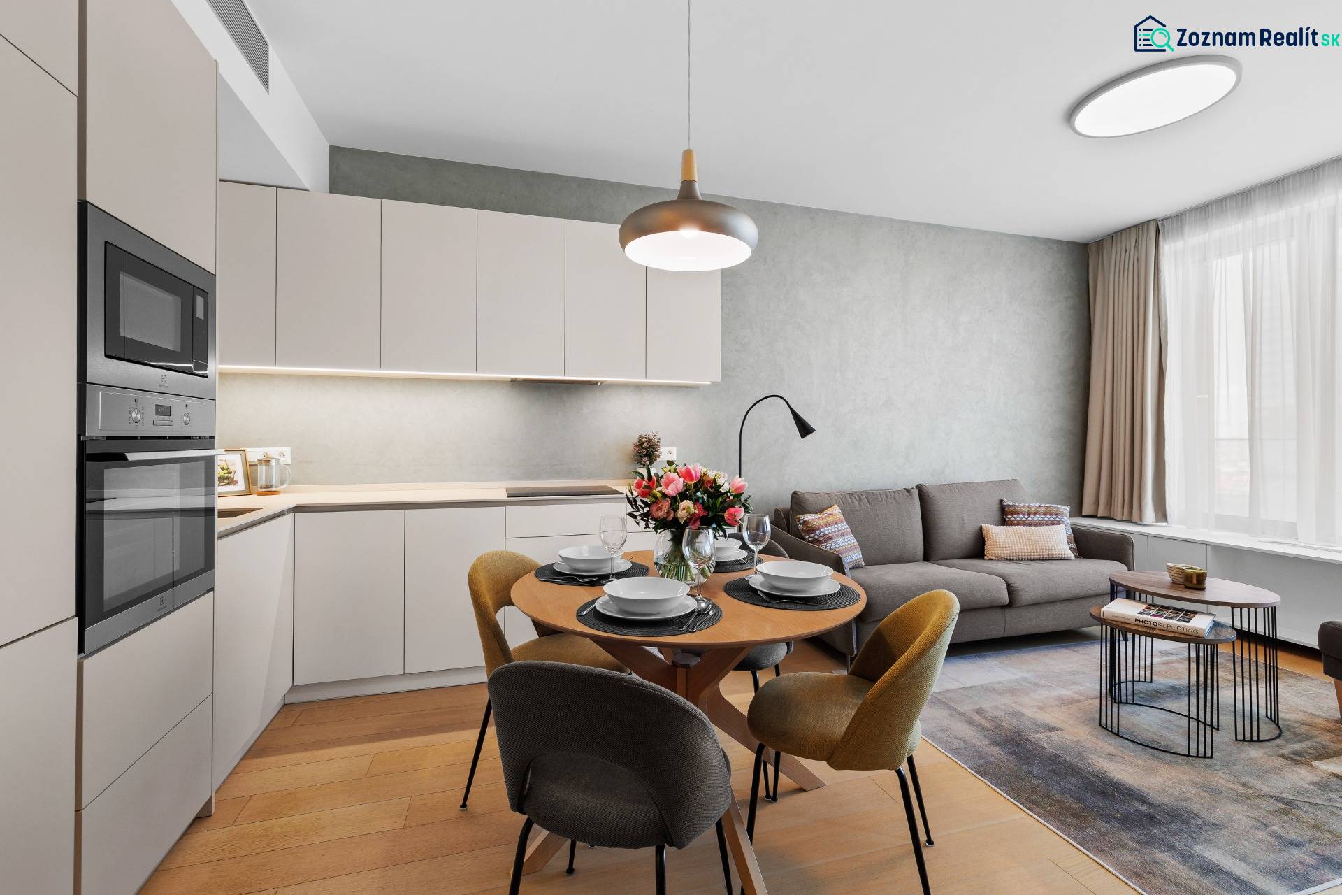 NUERA︱SKY PARK nadštandardný zariadený 2-izbový byt na 15. poschodí - Obývacia izba v 2-izbovom byte s podlahou s dreveným dekorom a kuchynským kútom.