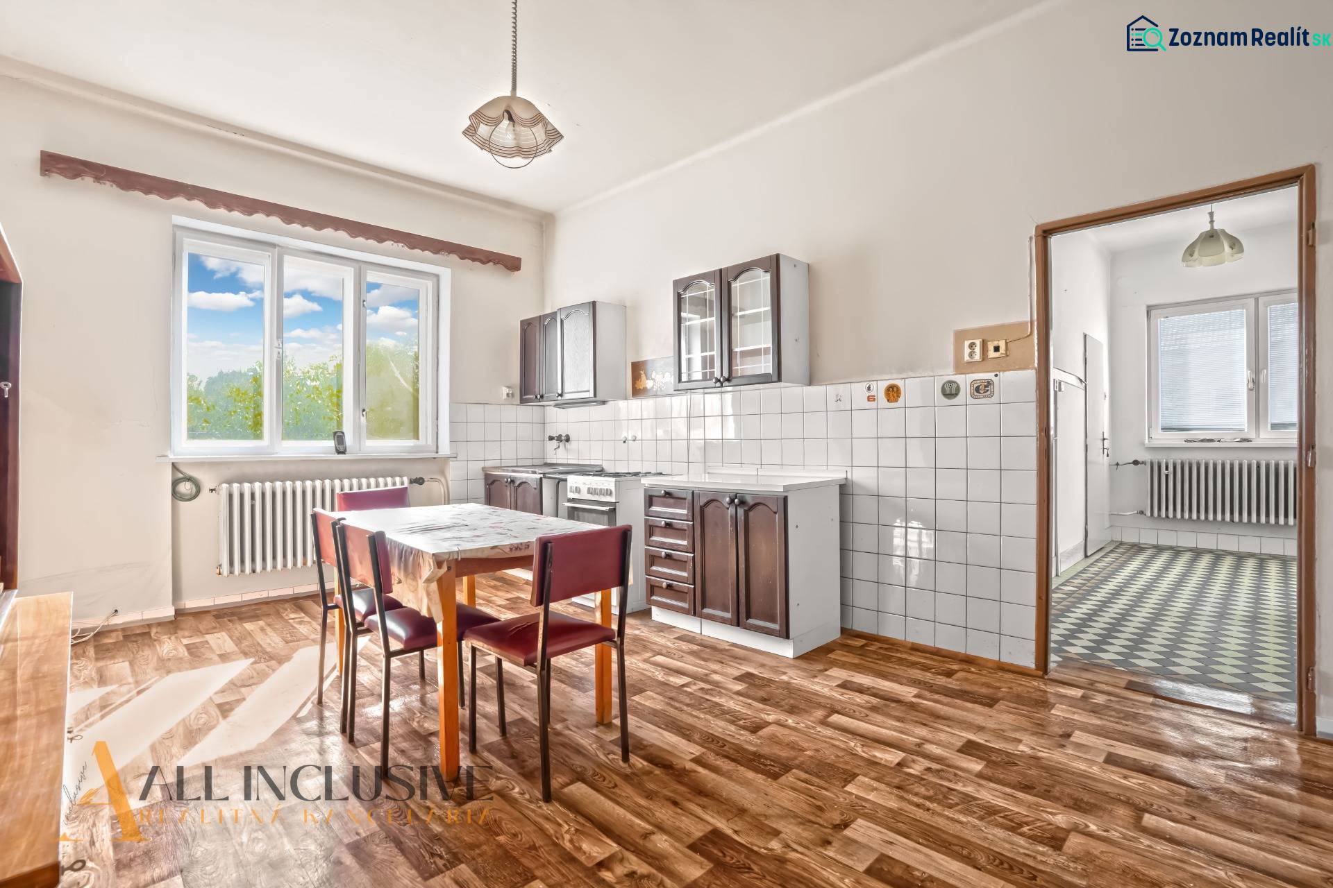 REZERVOVANÉ 3-IZBOVÝ RD NA PRIESTRANNOM POZEMKU, VRAKÚ - Kuchyňa v rodinnom dome s podlahou s dreveným dekorom, jedálenským stolom a stoličkami.