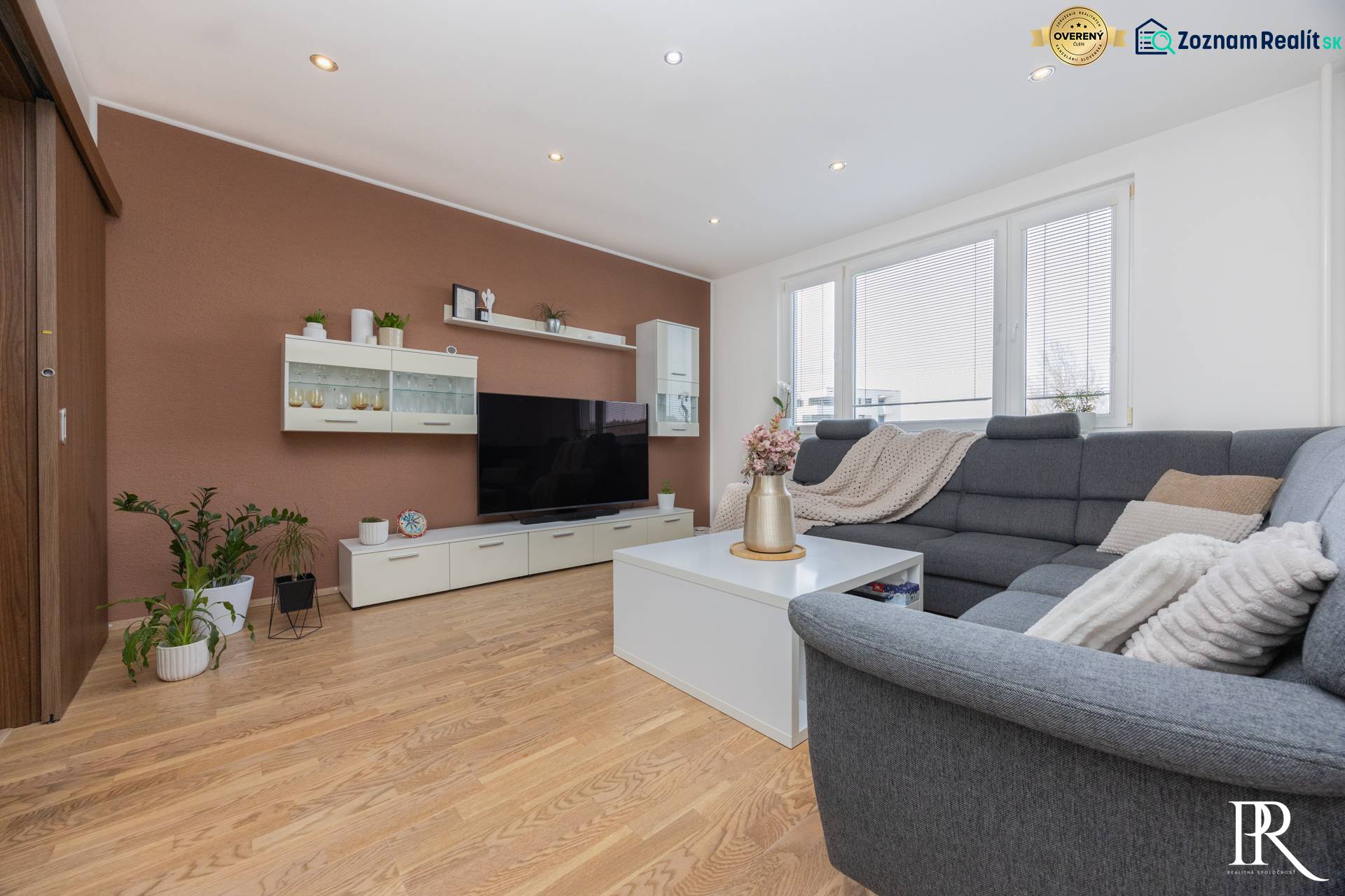 REZERVOVANÝ ZARIADENÝ 4-IZB.  BYT V TOP LOKALITE, DUBNICA NAD VÁHOM - Obývacia izba so sivou sedačkou, bielym nábytkom, podlaha s dreveným dekorom, 4-izbový byt.