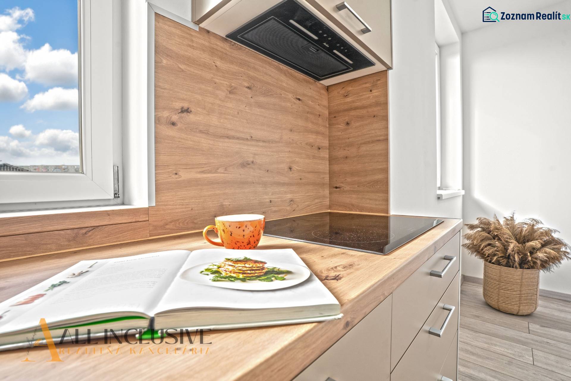 NA PRENÁJOM 3-IZB BYT S BALKÓNOM A ZÁHRADOU,DUN.STREDA - Kuchyňa s podlahou s dreveným dekorom v 3-izbovom byte. V popredí oranžový hrnček.