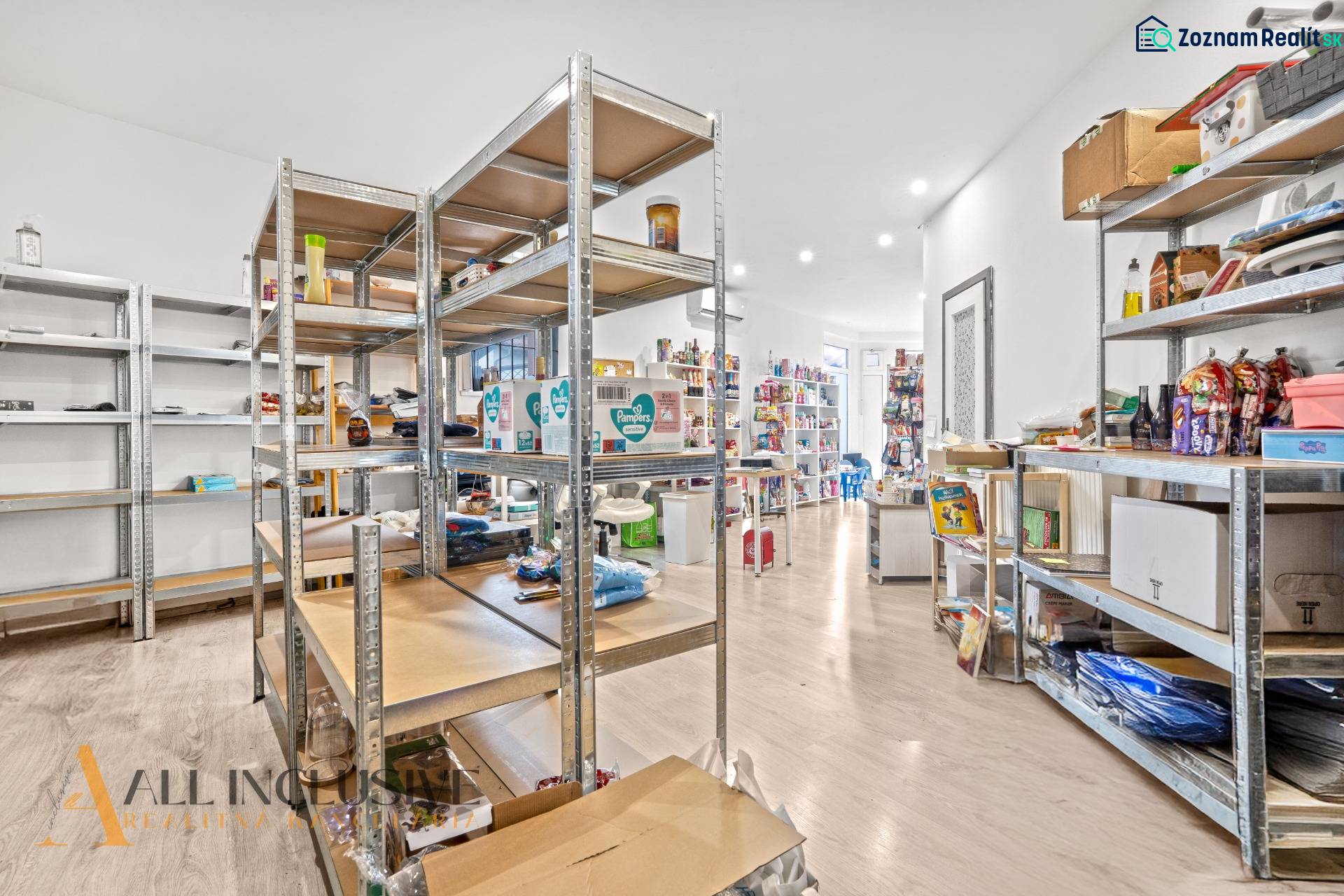 NA PREDAJ NEBYTOVÝ PRIESTOR V DUNAJSKEJ STREDE - Obchodné priestory so skladmi a regálmi, podlaha s dreveným dekorom, rôzne produkty.