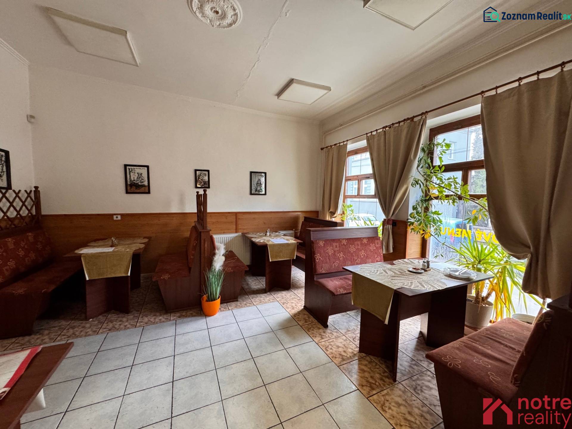 Podnikateľský objekt na prenájom v Lučenci - Drevený dekor sedenia v gastro priestoroch s rastlinami a dekoráciami na stenách.