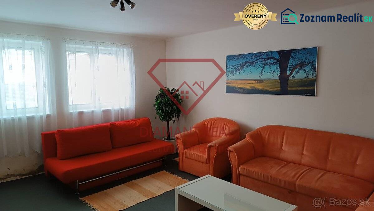 Na predaj RD na bývanie alebo investičná príležitosť Horné Saliby - Obývacia izba v rodinnom dome s oranžovou sedačkou, kreslami a obrazom krajiny.