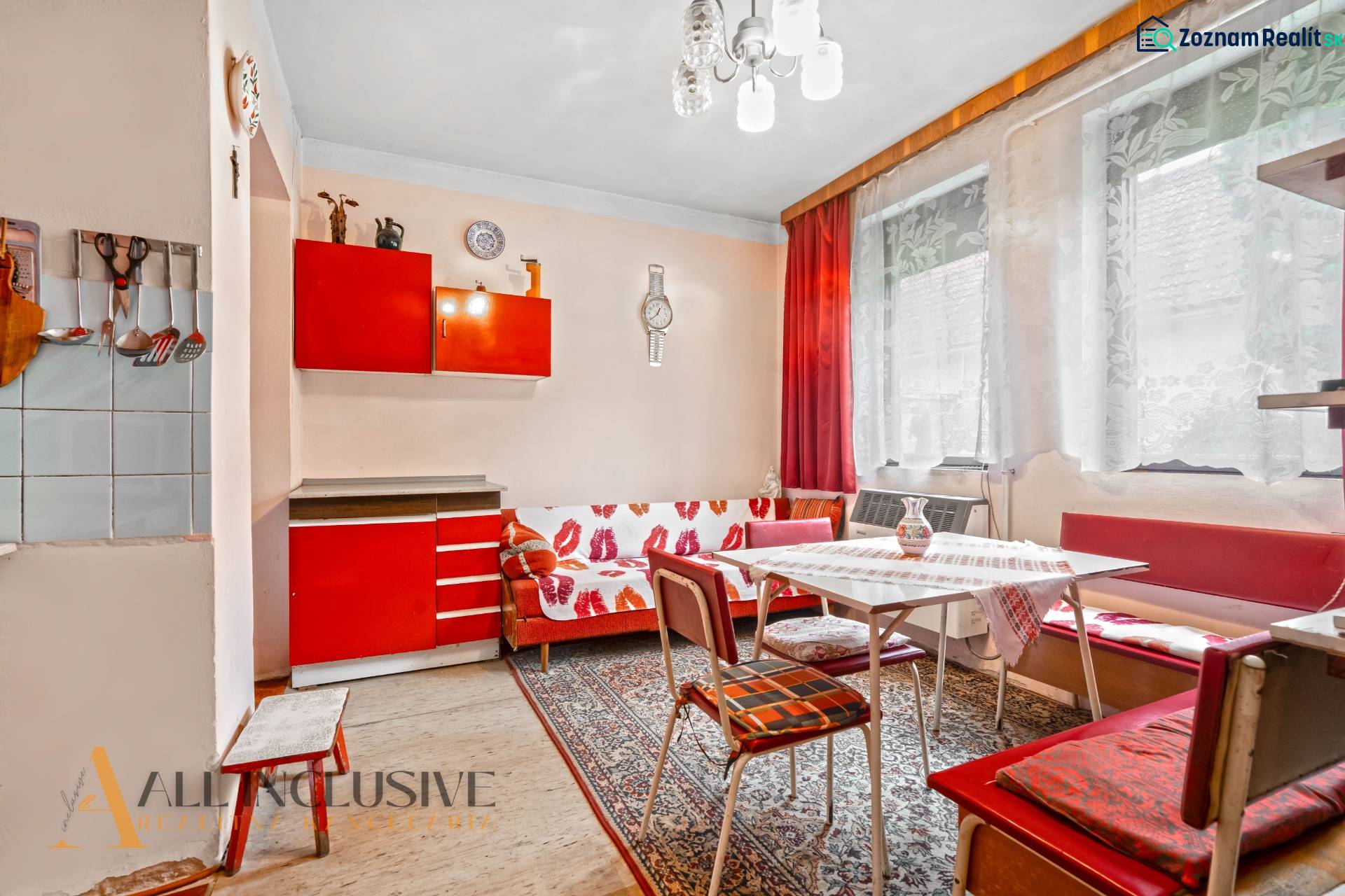 NA PREDAJ 2-IZBOVÝ RODINNÝ DOM S PODKROVÍM, BODÍKY - Interiér rodinného domu s červenou kuchynskou linkou a textilným dekorom na stene.