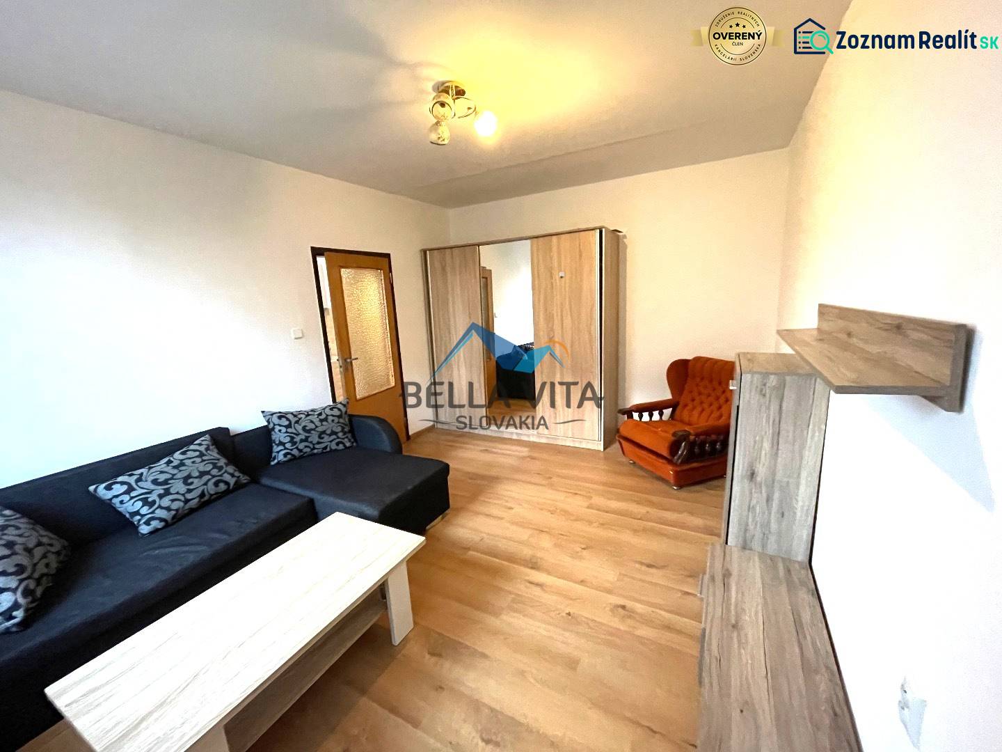 EXKLUZÍVNY PREDAJ - 1 izbový byt Revolučná Štvrť , Galanta - Obývacia izba v 1-izbovom byte s pohovkou a podlahou s dreveným dekorom.