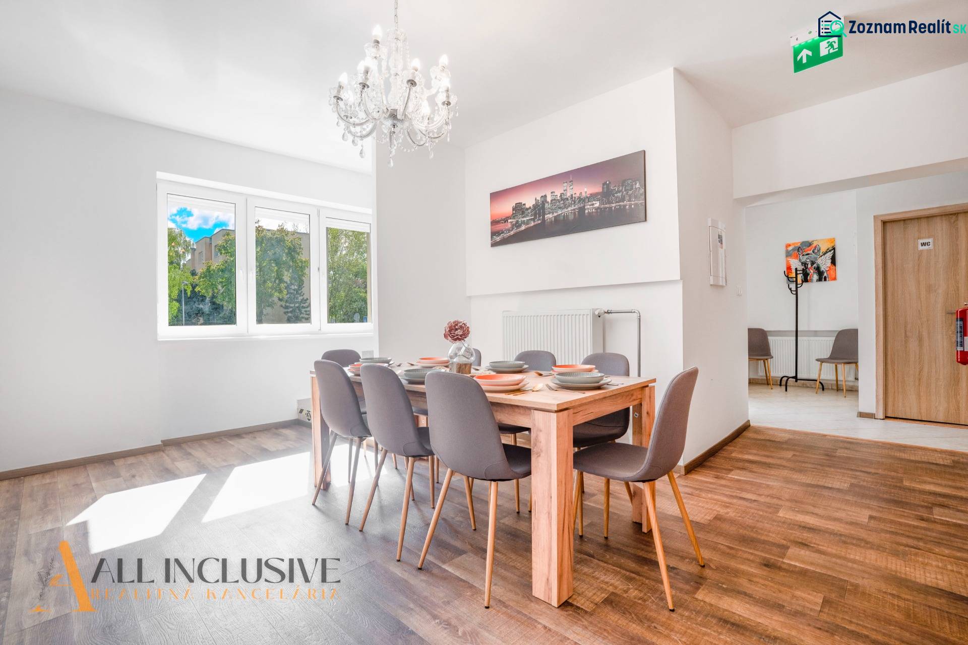 Na predaj 7-izb. RD s obchod. priestorom, Dun. Streda - Jedáleň s lusterom a podlahou s dreveným dekorom v budove.