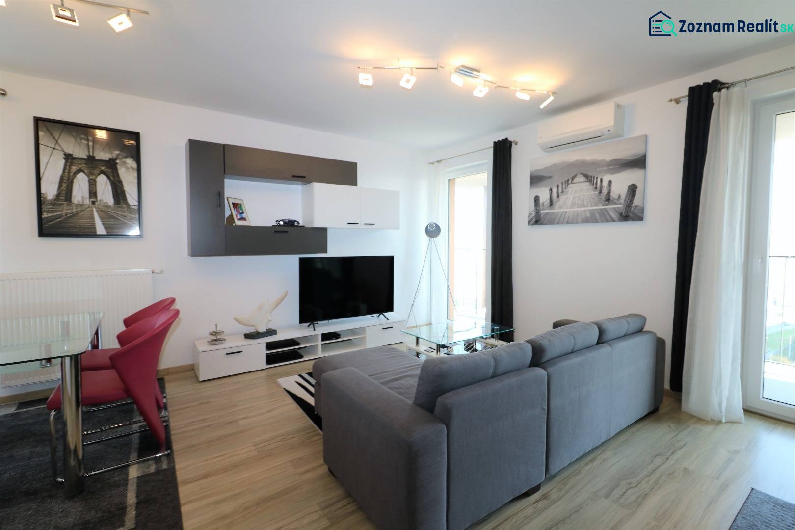 NUERA︱ SLNEČNICE- slnečný 2izbový byt s výhľadom na hrad - Obývacia izba v 2-izbovom byte s pohovkou, TV, podlahou s dreveným dekorom.