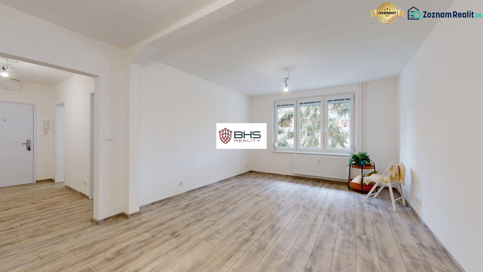 PREDAJ - 4-izb. byt na Sklenárovej ul., 67 m2, komplet. rekonštrukcia - Priestranná izba v 4-izbovom byte s podlahou s dreveným dekorom a veľkými oknami.