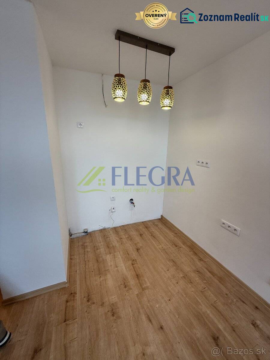 Na predaj 1,5-izbový byt v novostavbe GREENSIDE Trebišov - Interiér 1-izbového bytu s podlahou s dreveným dekorom a závesnými svietidlami.