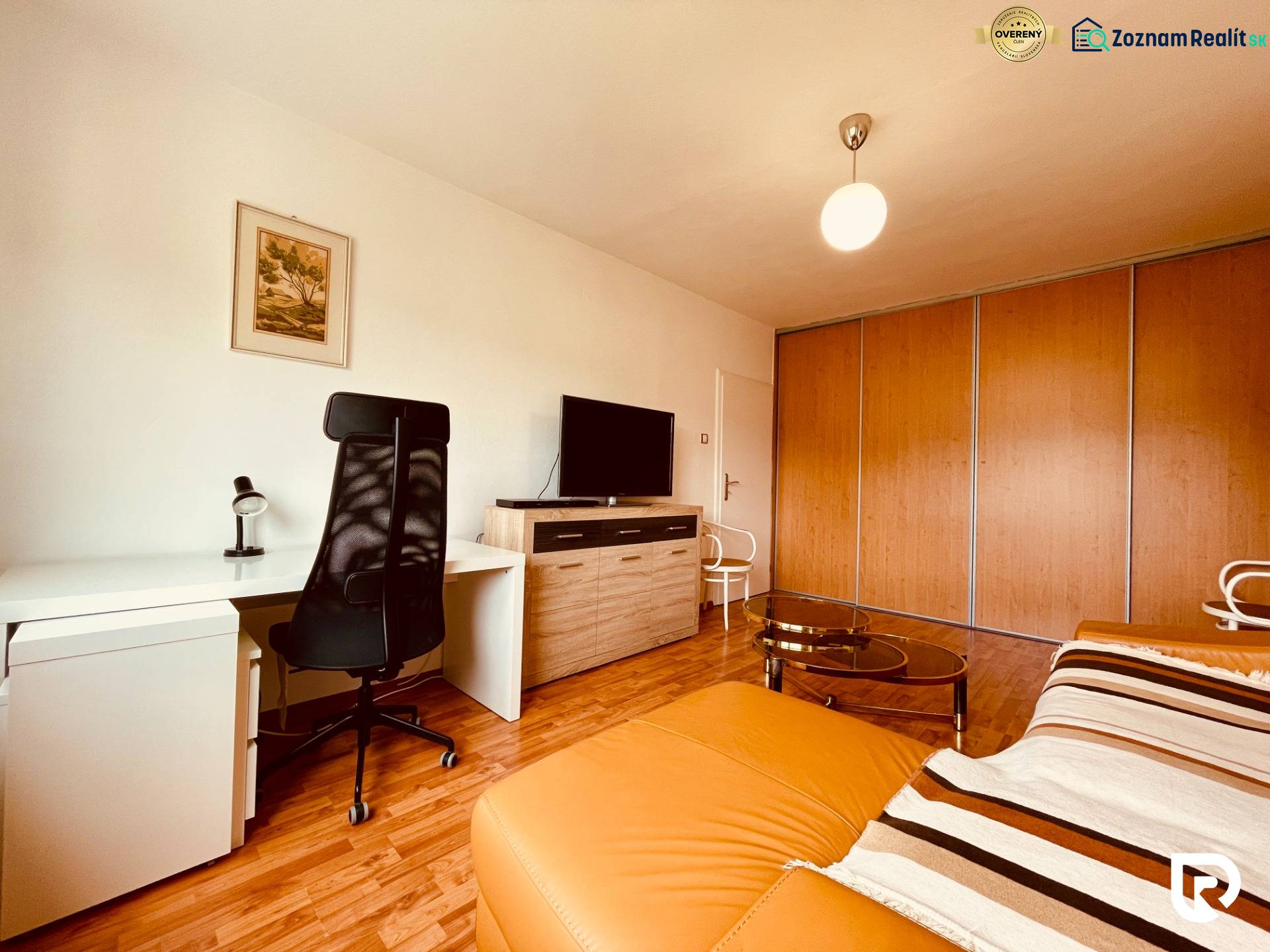 EXKLUZÍVNE! | Krásny 2-izbový byt | 52m² | Považanova - Izba v 2-izbovom byte s podlahou s dreveným dekorom, písacím stolom a sedačkou.