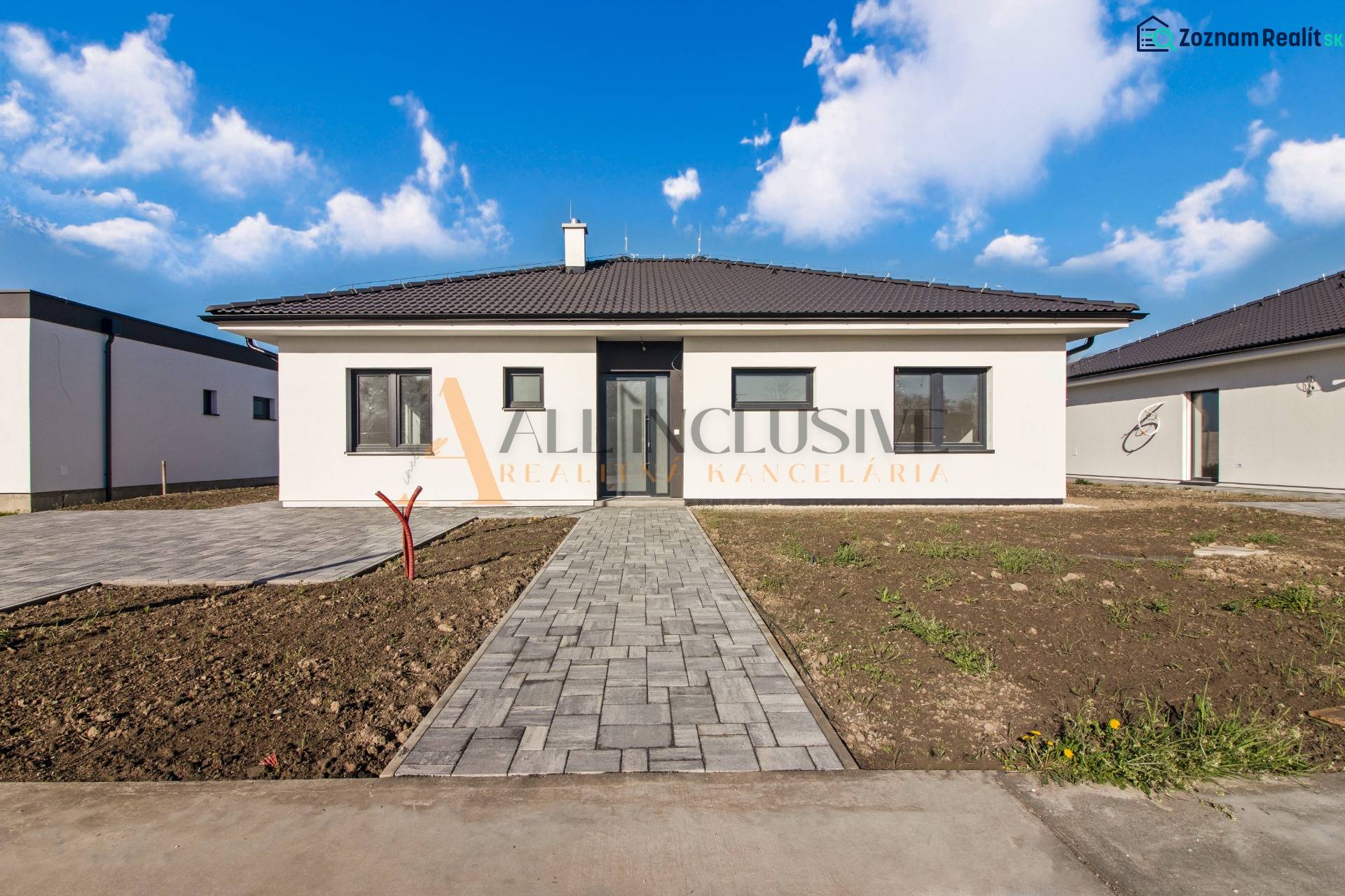 NA PREDAJ 4 IZBOVÝ RODINNÝ DOM-NOVOSTAVBA, KRÁĽOV BROD - Jednopodlažný rodinný dom s tmavou strechou a upraveným dvorom pod modrou oblohou.