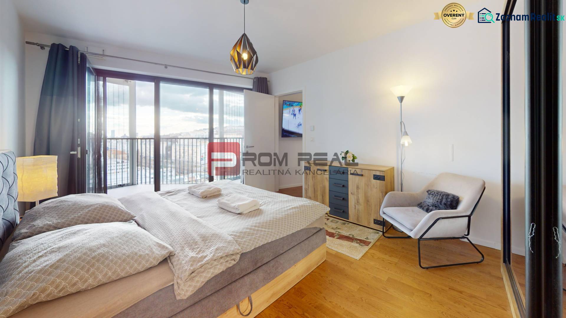 Na prenájom 2 izb. byt s parkovaním a veľkou terasou Guthaus - Spálňa s veľkou posteľou, kreslom a skriňou, podlaha s dreveným dekorom.