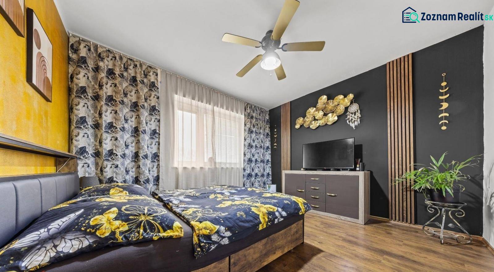 Na predaj 5-izb. rodinný dom na 50-á pozemku, Sap - Spálňa v rodinnom dome s farebnou posteľou, dreveným dekorom a výraznou nástennou výzdobou.