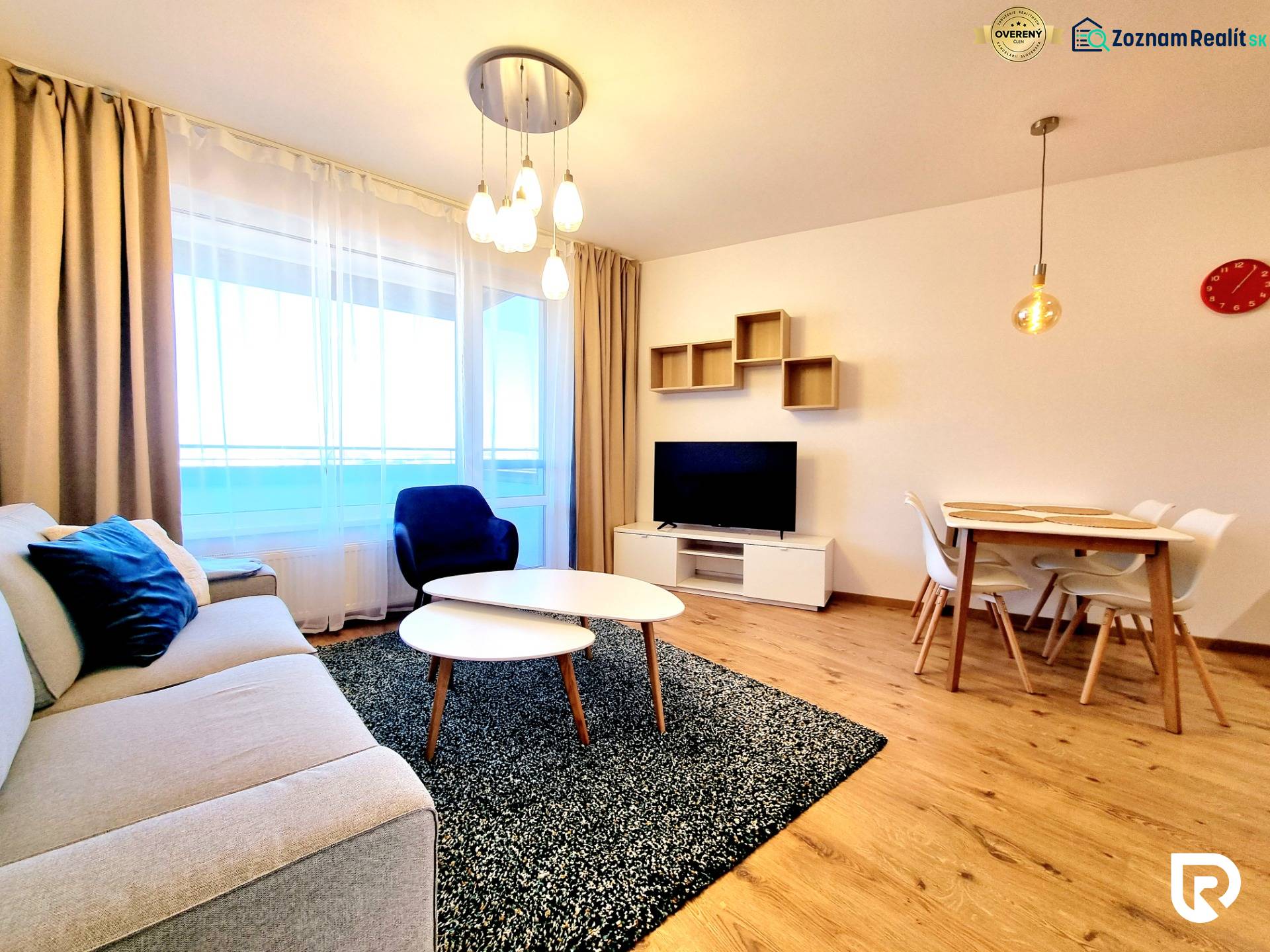 Posledný investičný krásny 2-izbový byt | 55 m² | RÍNOK RAČA - Obývacia izba s pohovkou, televízorom a jedálenským stolom, podlaha s dreveným dekorom.