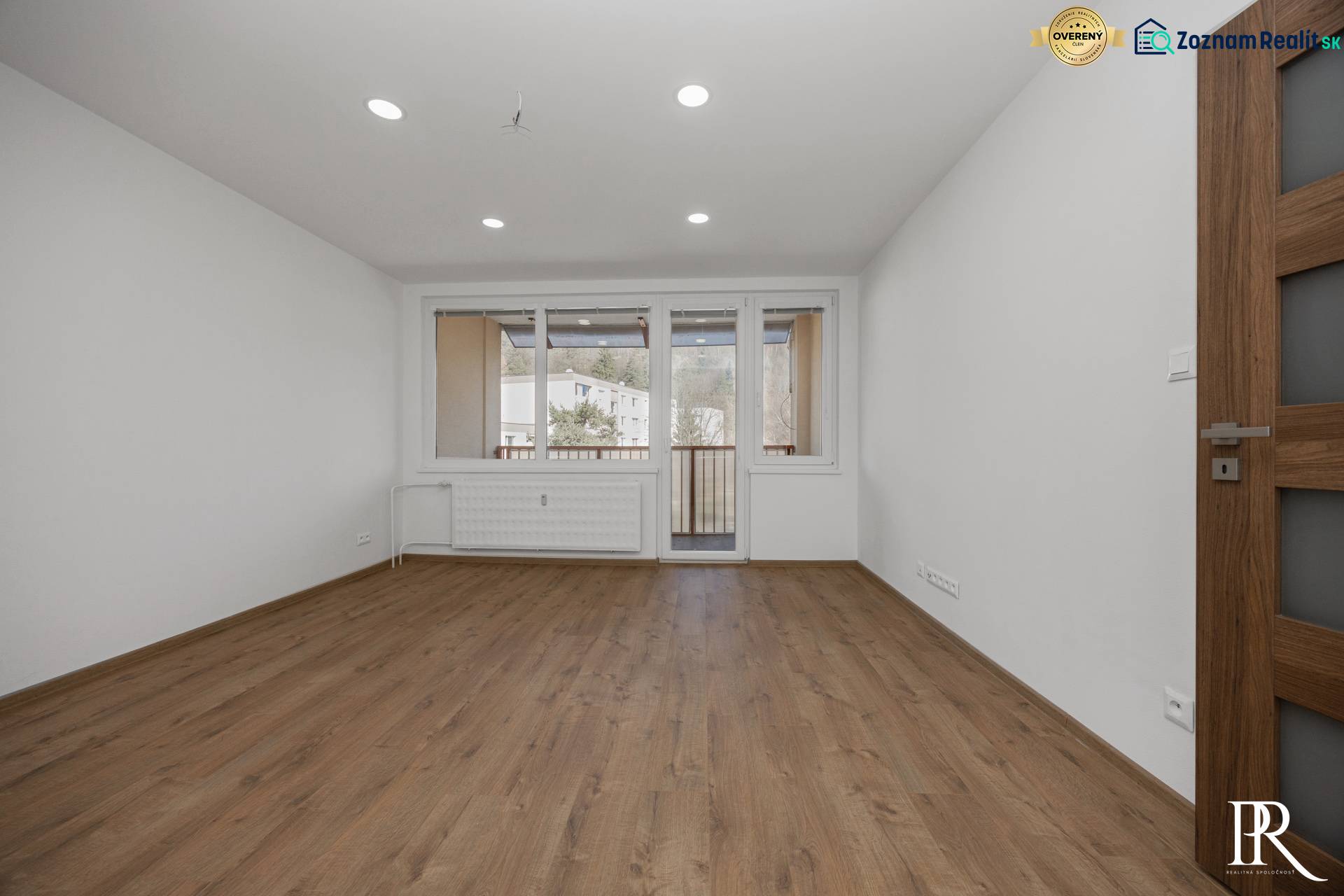 KRÁSNY NOVOZREKONŠTRUOVANÝ 3IB, SNP,POVAŽSKÁ BYSTRICA - Svetlá izba v 3-izbovom byte s podlahou s dreveným dekorom a balkónovými dverami.