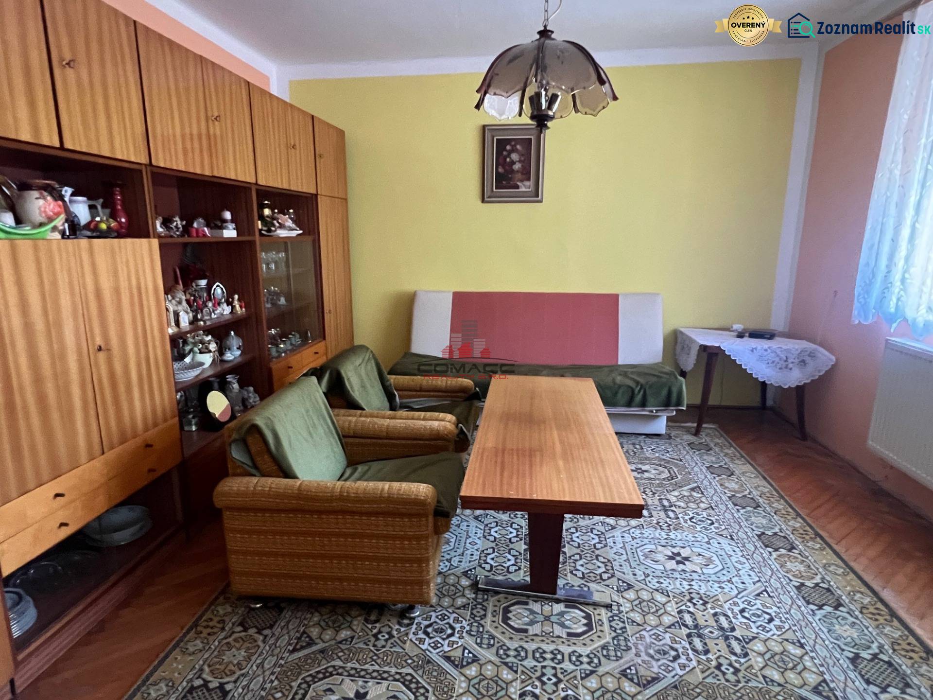 RD Drahovce ZĽAVA !!! - Obývačka v rodinnom dome s retro nábytkom, zelenými kreslami a veľkým kobercom.