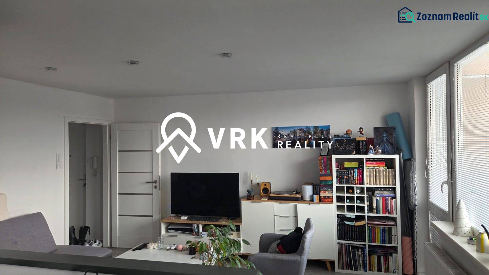 3 IZBOVÝ BYT, HUMENSKÁ, KOŠICE-ZÁPAD - Obývacia miestnosť 3-izbového bytu s knihovničkou, televízorom a svetlým nábytkom.