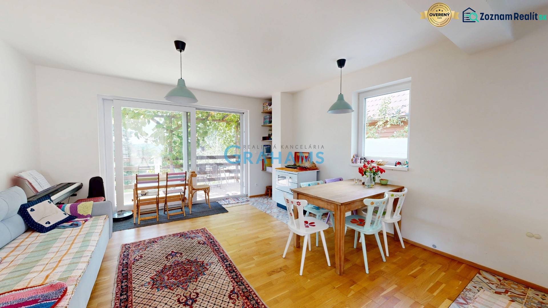 3D, Predaj novostavba, celoročne obývateľná chata, Stupava, Ovocinár   - Interiér chaty s jedálenským stolom, kreslom a klavírom, svetlá a útulná atmosféra.