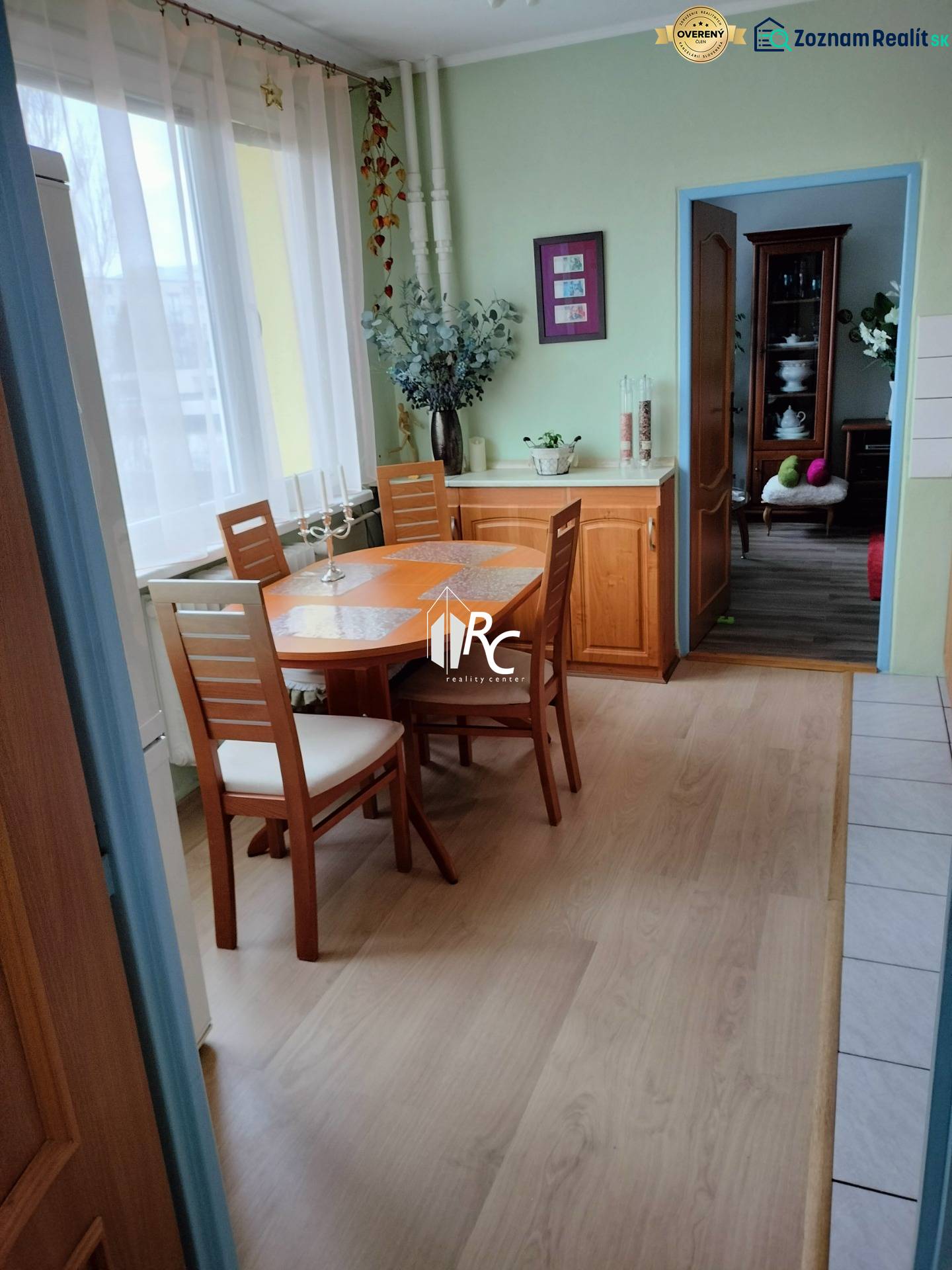 2 izbový byt na Severe - Jedálenský kút v 2-izbovom byte s podlahou s dreveným dekorom a svetlým nábytkom.