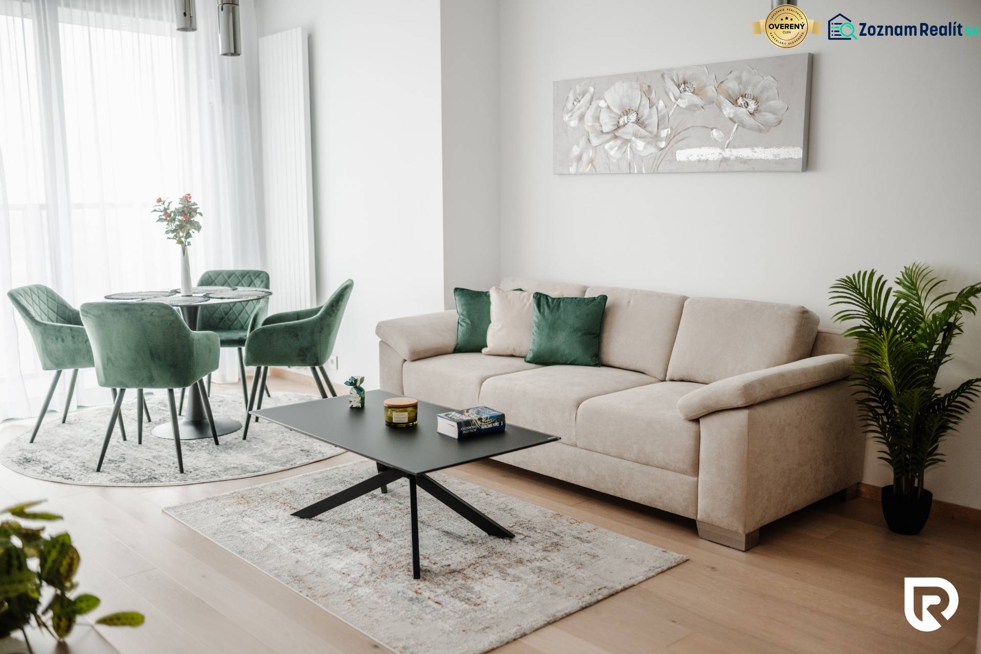 | E2Tower | 20.poschodie | 2i byt | panoramatický výhľad |  - Obývacia izba v 2-izbovom byte so svetlým gaučom a zelenými kreslami.