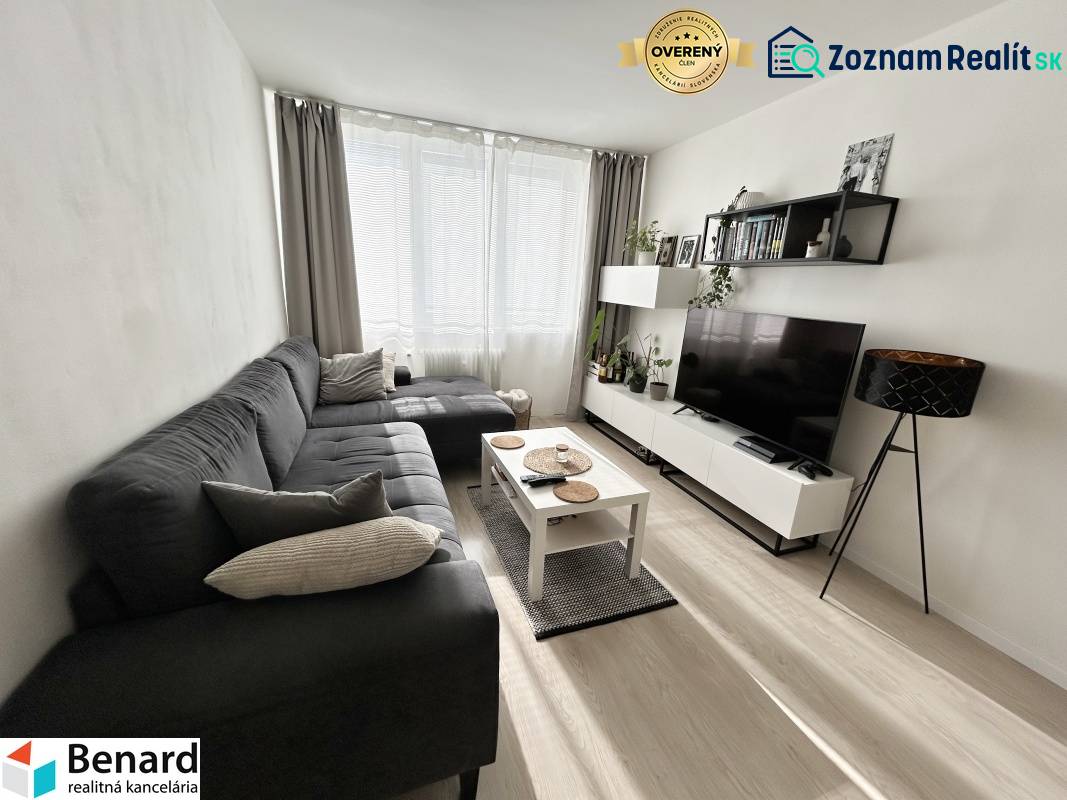 NA PREDAJ ŠTÝLOVÝ 2- IZBOVÝ BYT, 50m2, SÍDLISKO 2, PREŠOV - Obývačka v 2-izbovom byte s podlahou s dreveným dekorom a sedačkou.