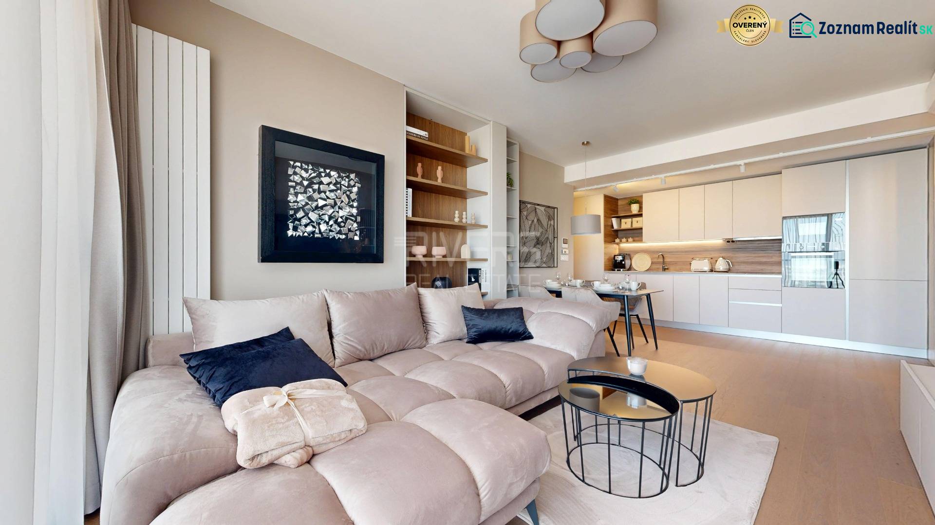 RIVERS | Butikovo zariadený ateliér na 32. poschodí Eurovea Tower - Svetlá obývačka v 2-izbovom byte s pohovkou, kuchyňou a podlahou s dreveným dekorom.