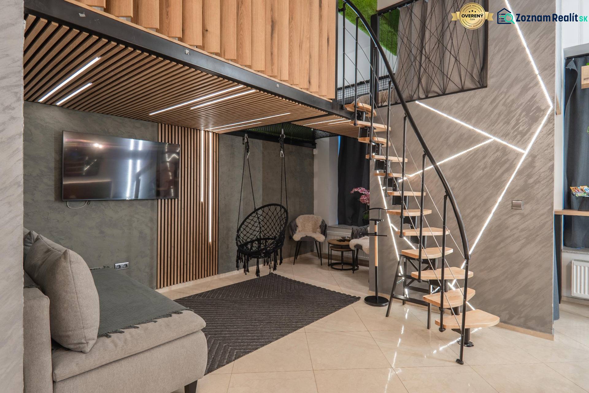| Luxusný dvojúrovňový mezonet v Starom Meste - Interiér 3-izbového bytu s podlahou s dreveným dekorom a štýlovými schodmi.