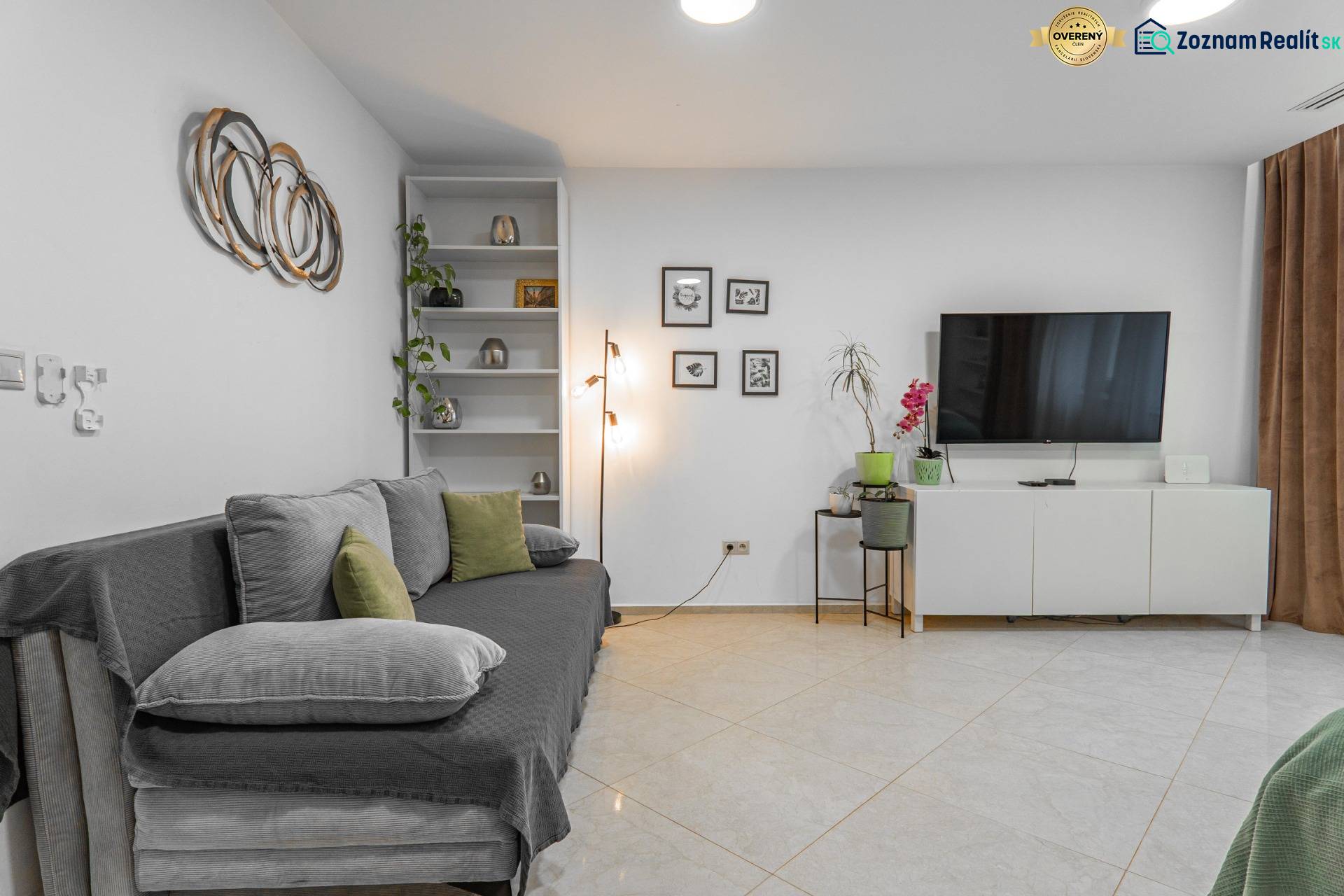 I Luxusný byt v historickom centre Bratislavy - Obývačka v 2-izbovom byte s TV, pohovkou a minimalistickou dekoráciou na bielej stene.