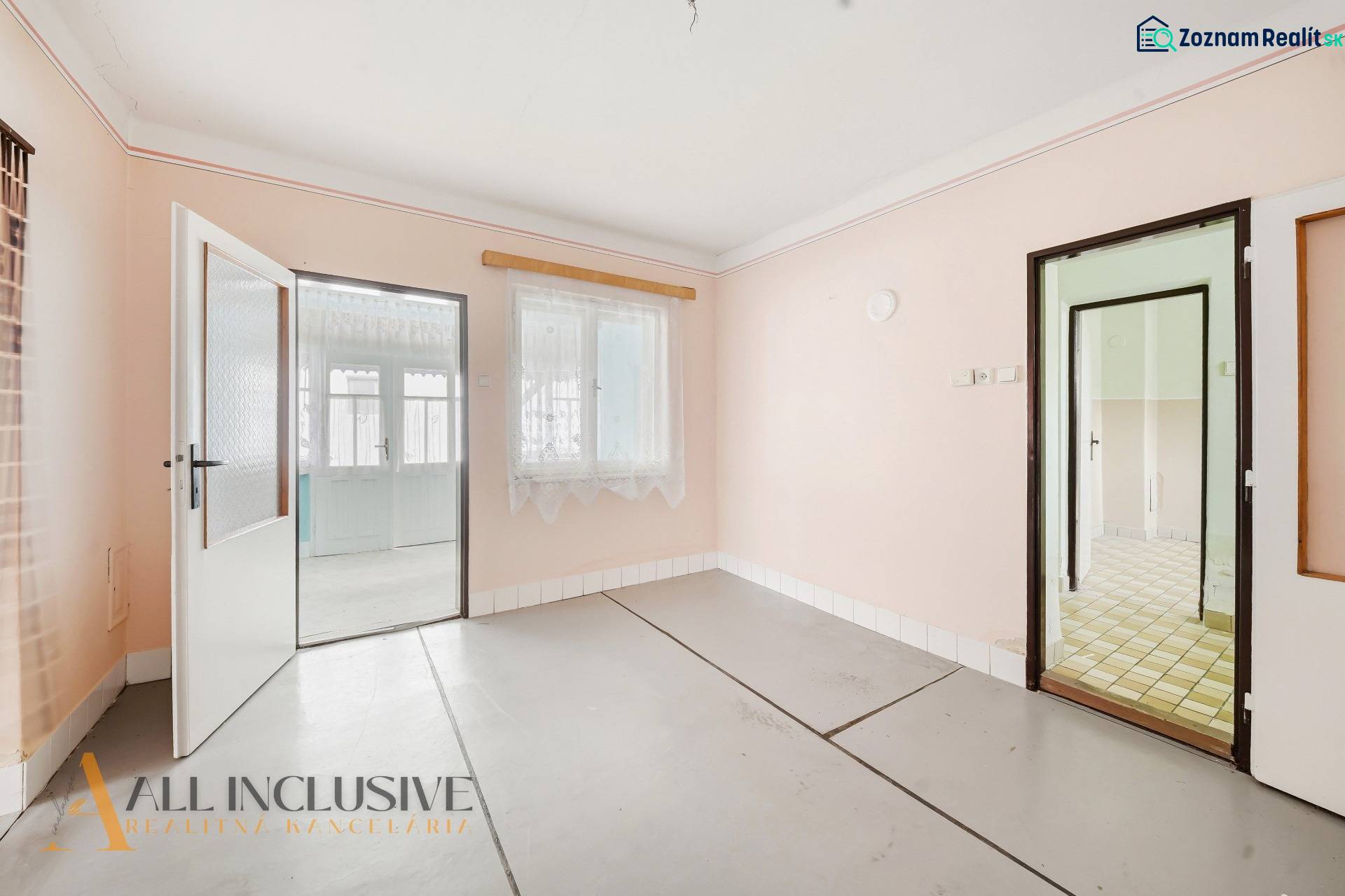 Na predaj 4-izbový rodinný dom, Topoľníky - Interiér rodinného domu s bielymi stenami a presklenými dverami bez dreveného dekoru.