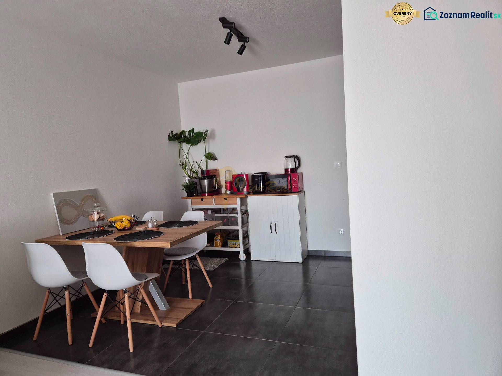 3-izb. byt v obci Blatná na Ostrove, balkón, lodžia, novostavba - Jedálenský kút s dreveným stolom, štyrmi stoličkami a rastlinou v 3-izbovom byte.