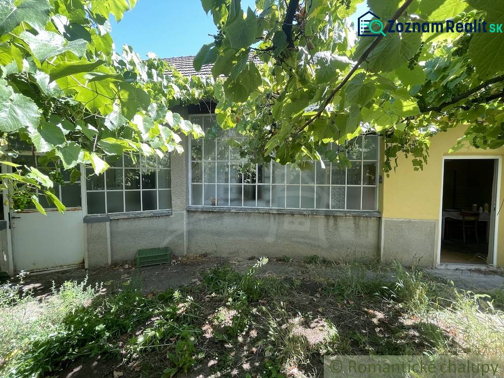 Rodinný dom v pôvodnom stave na 7 árovom pozemku v Tvrdošovciach - Rodinný dom v Tvrdošovciach s verandou obklopený zeleňou, záhrada s viničom.