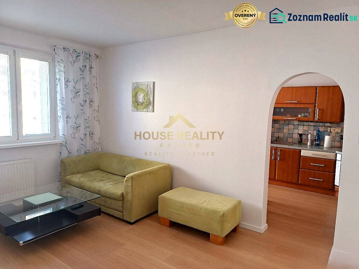 Zariadený 3 izbový byt s lodžiou, Beniakova ulica, BA IV. Karlova Ves - Obývacia izba v 3-izbovom byte s pohovkou, stolíkom a kuchynským kútom.