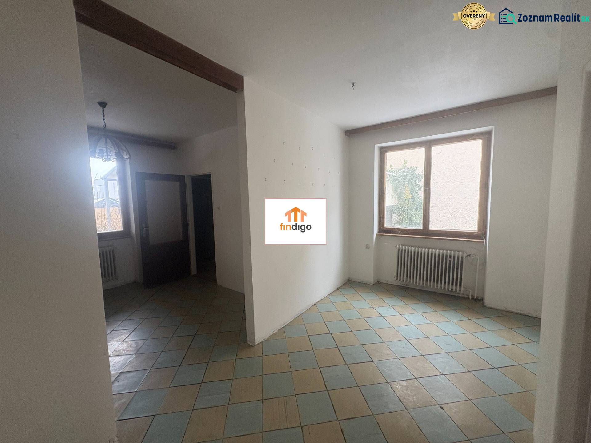 PREDAJ - Rodinný dom s investičným potenciálom - Nové Zámky - Interiér rodinného domu s keramickou podlahou, radiátorom a veľkým oknom.