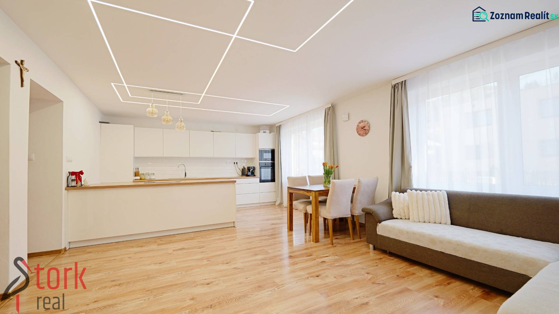 TOP - Rodinný dom s veľkým pozemkom - Dolný Hričov - Interiér rodinného domu s kuchyňou a obývačkou, podlahou s dreveným dekorom a svetlým nábytkom.